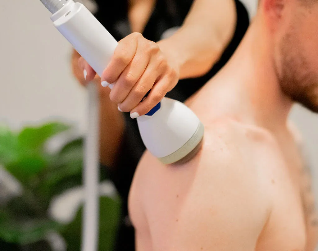 SoftWave treatment on a patient's upper back
